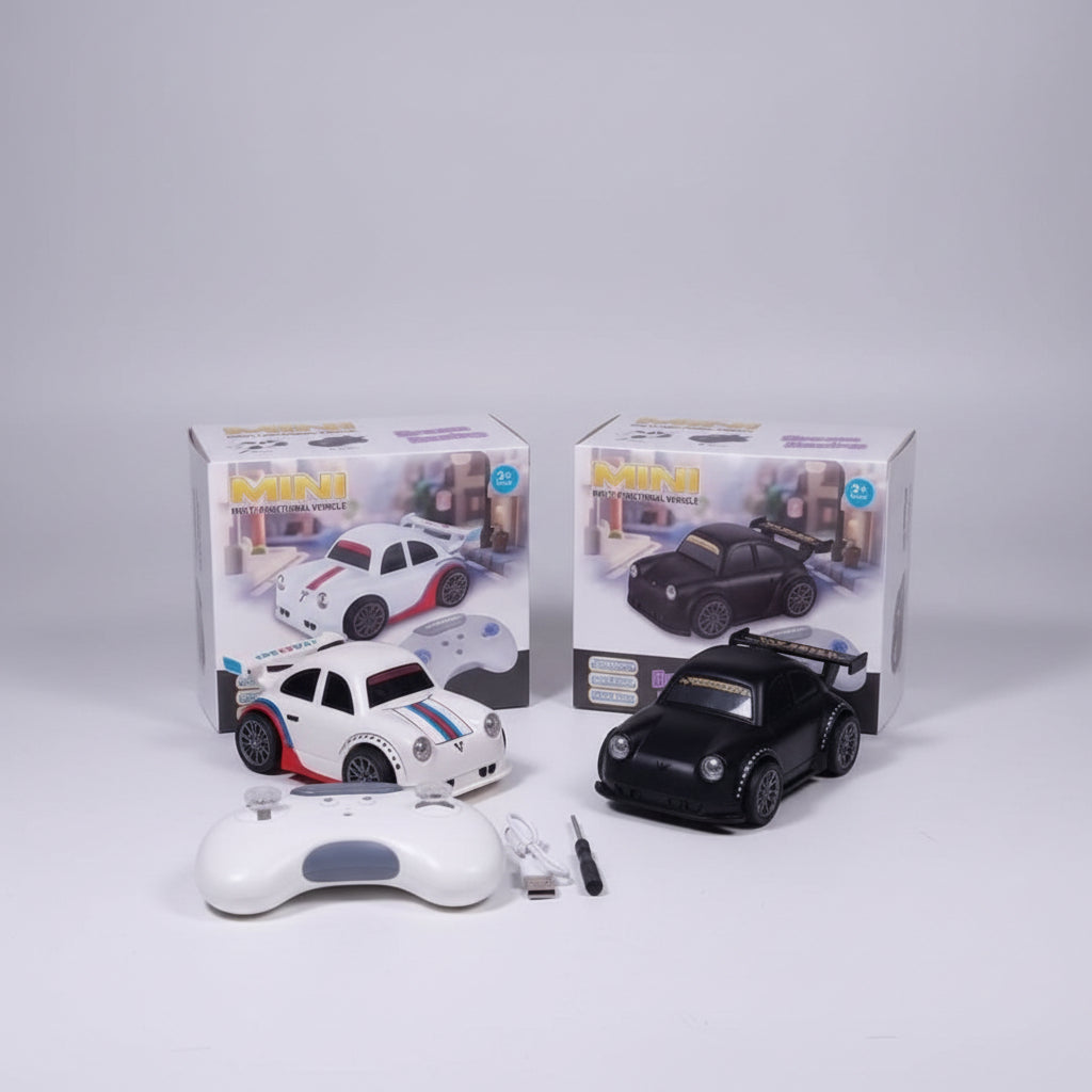 A remote control toy racing car set displayed on a green textured surface, including a white remote car with red and blue stripes, a black remote car, a white wireless controller, a USB charging cable, a small screwdriver, and two product boxes in the background.
